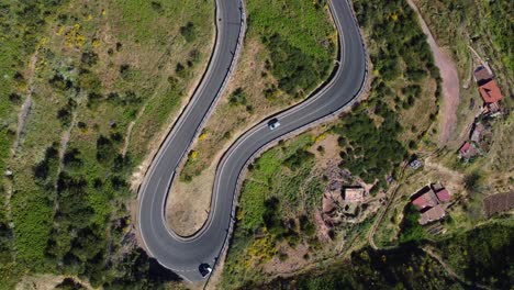 Filmische-Luftaufnahme-Einer-Drohne,-Die-Auf-Einer-Kurvenreichen-Straße-Auf-Ein-Auto-Herabblickt-–-Gran-Canaria,-Spanien