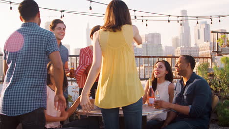 Friends-Gathered-On-Rooftop-Terrace-To-Celebrate-Birthday-With-City-Skyline-In-Background