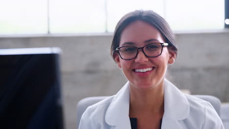 Young-female-doctor-in-glasses-smiling-to-camera,-close-up