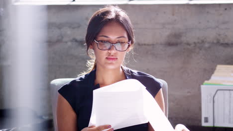 Young-businesswoman-checking-paperwork-in-her-office