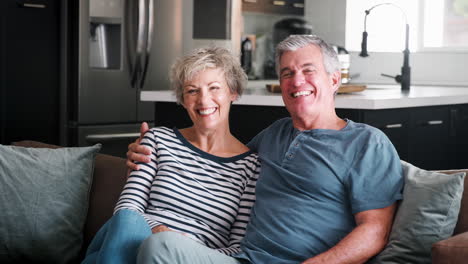 Senior-white-couple-relaxing-at-home-smiling-to-camera