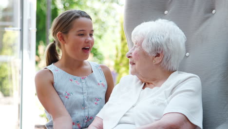 Enkelin-Sitzt-Und-Redet-Mit-Großmutter-Während-Eines-Besuchs-Im-Altersheim