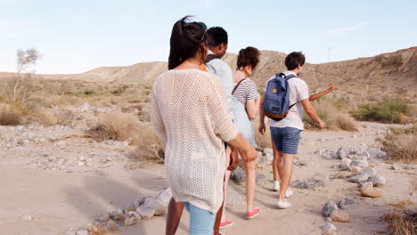 Five-young-adults-hiking-in-Palm-Springs-desert,-follow-shot
