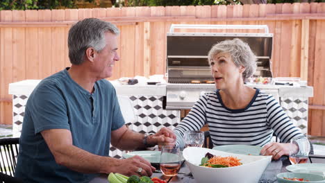 Senior-white-couple-talking-together-at-lunch-in-the-garden