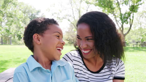Slow-Motion-Portrait-Of-Smiling-Mother-With-Son-Relaxing-In-Park
