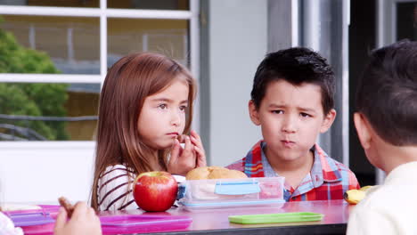Four-elementary-schoolchildren-having-lunch-together