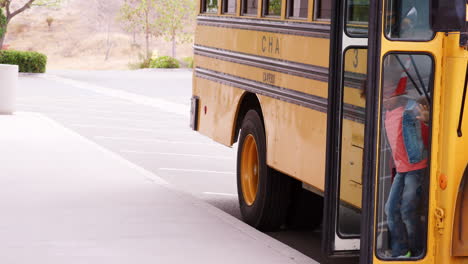 Niños-De-Primaria-Bajando-Del-Autobús-Escolar-Por-La-Mañana