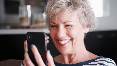 Ältere-Frau,-Die-Zu-Hause-Videoanrufe-Auf-Dem-Smartphone-Macht,-Aus-Nächster-Nähe