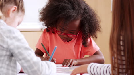 Elementary-school-schoolgirl-in-glasses-drawing-at-art-class