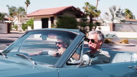 Senior-white-couple-on-the-road-in-a-convertible,-close-up