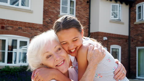 Granddaughter-Greeting-Grandmother-On-Visit-To-Retirement-Home