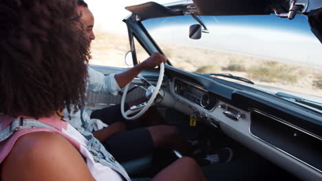 Black-couple-in-open-top-car-on-a-desert-highway,-close-up