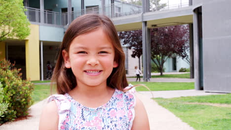 Elementary-schoolgirl-smiling--to-camera-in-school-yard