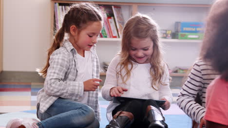 Zwei-Grundschulschülerinnen-Teilen-Sich-Ein-Tablet-Im-Unterricht