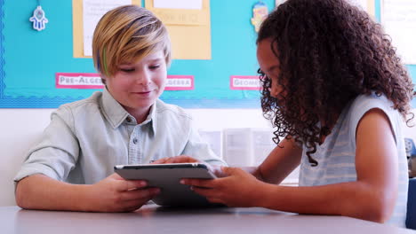 Dos-Niños-De-Escuela-Primaria-Con-Tablet-PC-En-Una-Lección