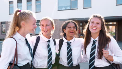Portrait-Of-Smiling-Female-High-School-Students-Wearing-Uniform-Outside-College-Building