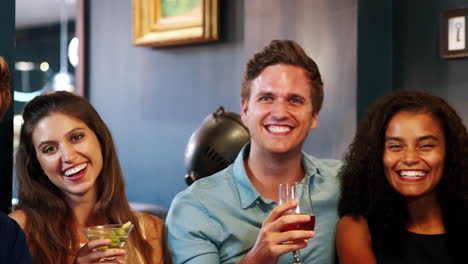 Portrait-Of-Young-Friends-Meeting-For-Drinks-In-Cocktail-Bar-And-Making-A-Toast