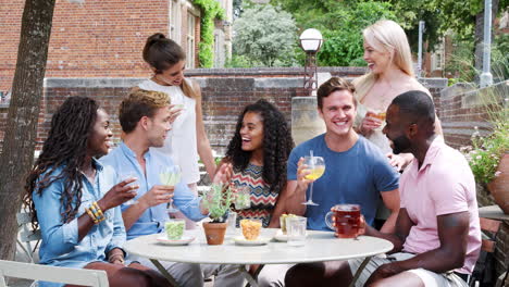 Portrait-Of-Friends-Meeting-For-Drinks-At-Outdoor-Tables-In-Restaurant