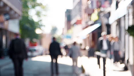 General-view-of-people-walking-in-a-city-street-on-sunny-day,--defocussed