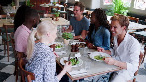 Group-Of-Young-Friends-Enjoying-Meal-In-Restaurant-Together