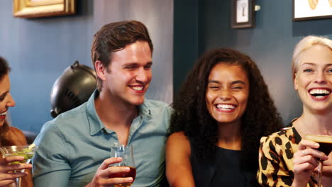 Portrait-Of-Young-Friends-Meeting-For-Drinks-In-Cocktail-Bar-And-Making-A-Toast