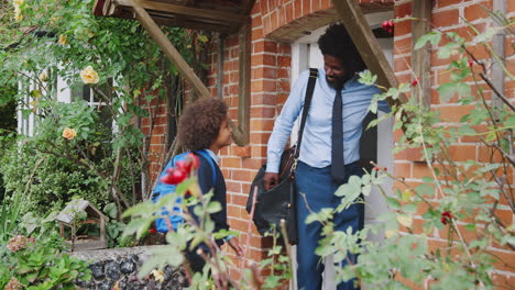 Smartly-dressed-middle-aged-black-man-and-his-pre-teen-son-in-school-uniform-leaving-their-house-in-the-morning,-exterior-view,-close-up