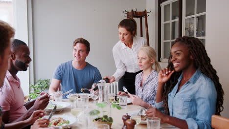 Waitress-Serving-Wine-To-Group-Of-Friends-Eating-Meal-In-Restaurant-Together