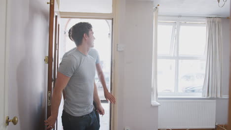 Excited-Male-Couple-Opening-Front-Door-Of-New-Home