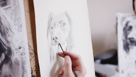 Close-Up-Of-Artist-Sitting-At-Easel-Drawing-Picture-Of-Dog-In-Charcoal