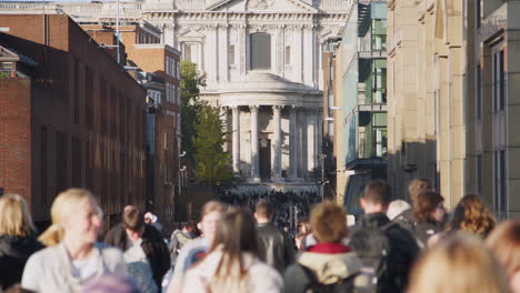 People-walking-in-the-narrow,-busy-street-leading-to-St-Paul's-Cathedral-in-London,-selective-focus