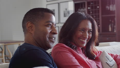 Nahaufnahme-Eines-Afroamerikanischen-Paares-Mittleren-Alters,-Das-Auf-Dem-Sofa-In-Seinem-Wohnzimmer-Sitzt-Und-Gemeinsam-Fernsieht