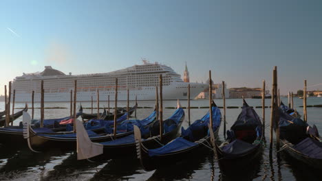 Cruise-liner-sailing-in-Venice-view-with-gondolas-mooring