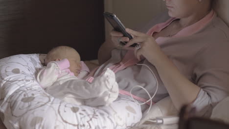 Anonyme-Frau-Mit-Baby,-Die-Ihr-Smartphone-Nutzt