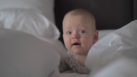 A-closeup-of-a-cute-baby-girl-on-white-sheets