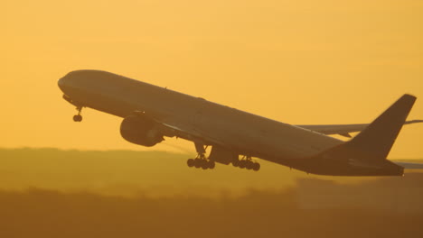 Aircraft-taking-off-and-ascending-against-golden-sunset-sky