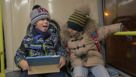Two-young-boys-riding-on-a-commuter-bus