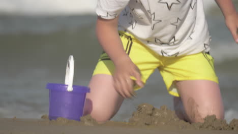 Kind-Spielt-Mit-Sand-Am-Meer