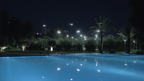 A-steadicam-shot-of-an-illuminated-open-pool-at-night