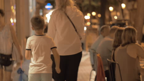 Mujer-Con-Dos-Niños-Caminando-En-La-Ciudad-De-Noche