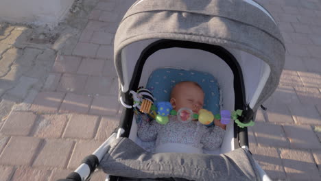 A-cute-baby-girl-sleeping-in-a-moving-baby-carriage