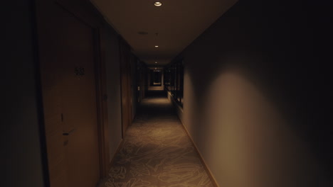 A-steadicam-shot-of-a-long-dark-hotel-hallway-with-large-windows