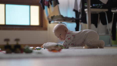 Baby-girl-crawling-on-the-floor-with-toys