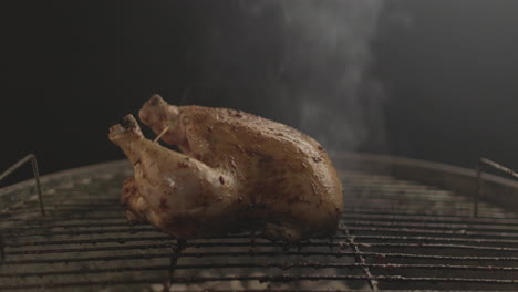 Pollo-Asado-Sobre-Carbón-Y-Fuego-Con-Humo-Saliendo-Con-Fondo-Negro-Filmado-Crudo-Y-A-Nivel-De-Los-Ojos-4k