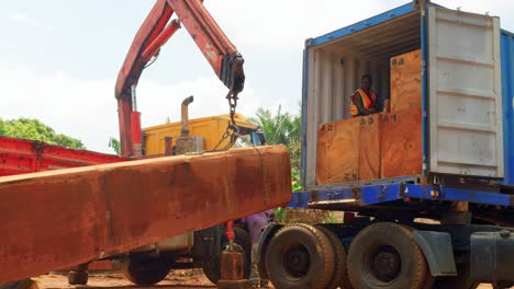 loading-a-big-piece-of-cut-wooden-tree-into-a-truck-in-africa