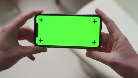 Zwei-Hände-Halten-Ein-Smartphone-Mit-Grünem-Bildschirm-Und-Tracking-Markern-Und-ändern-Die-Ausrichtung-Von-Querformat-Zu-Hochformat,-Dann-Wieder-Zu-Querformat-Und-Wieder-Zurück-Zu-Hochformat
