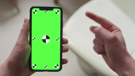 finger-pointing-on-smartphone-with-green-screen-display-with-tracking-markers-then-thumbs-up,-portrait-orientation