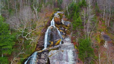 Rich-Landscape-with-Steep-Waterfall-Washing-Down-Colorful-Rocks-and-Boulders-in-the-Middle-of-Autumn-Forest