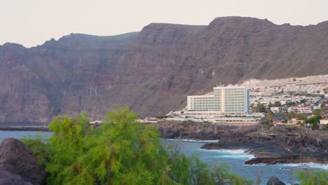 panning-across-resorts-and-establishments-at-the-seaside-of-Canary-Island-in-Tenerife-towards-the-sea,-handheld