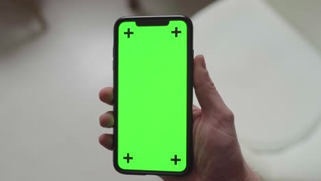 swinging-a-smartphone-in-front-of-the-camera-with-green-screen-display-and-tracking-markers,-static