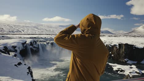 Man-come-near-Godafoss-waterfall-sightseeing-area-and-look-into-far
